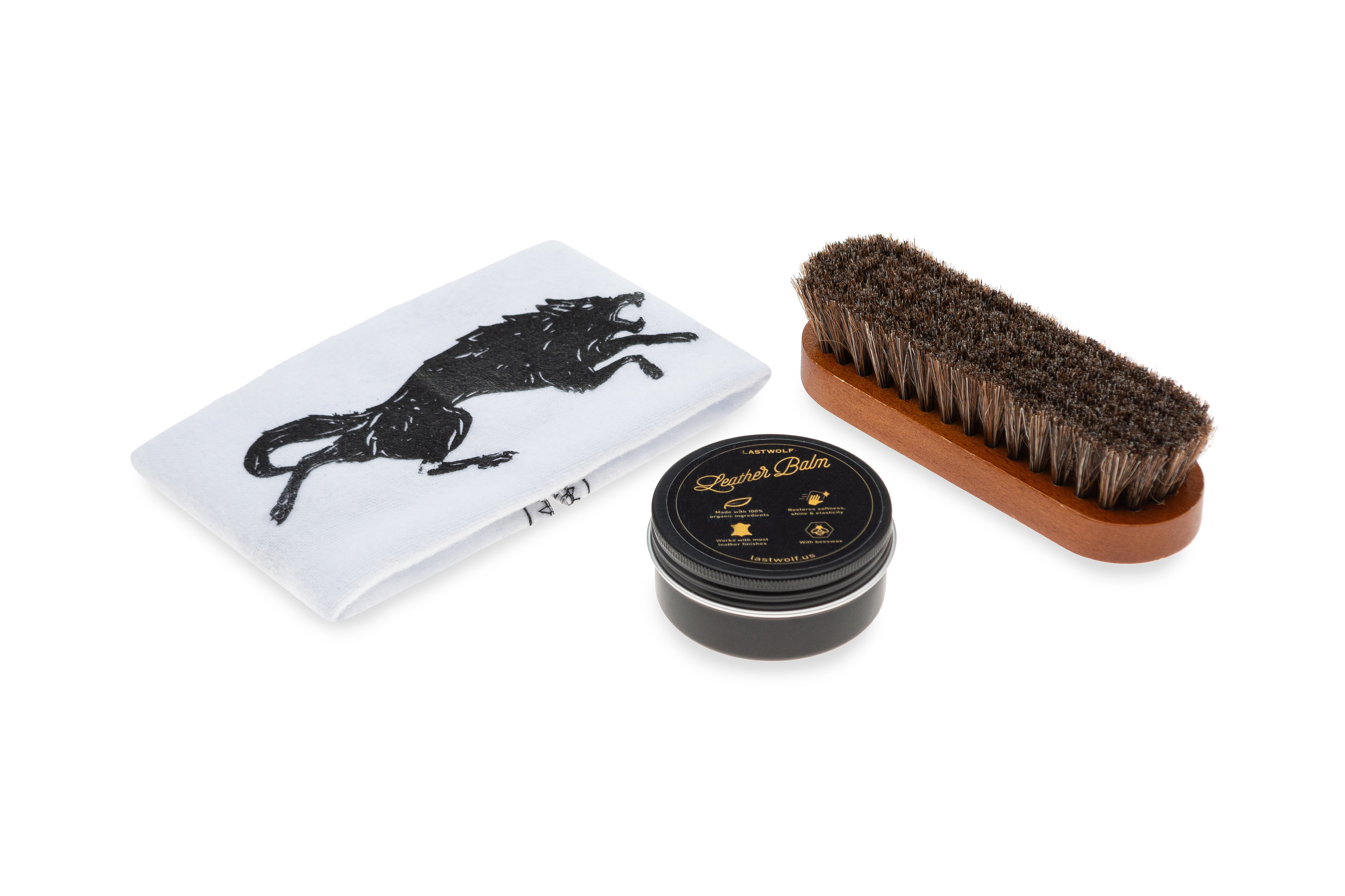 Set of horse grooming tools including a brush, tin, and cloth with Lastwolf logo design on a white background.