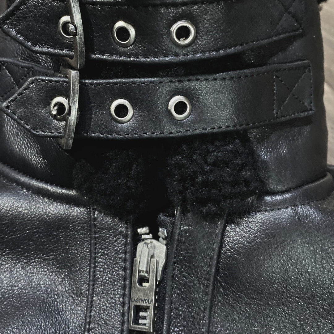 Close-up of black leather boot with metal eyelets and zipper