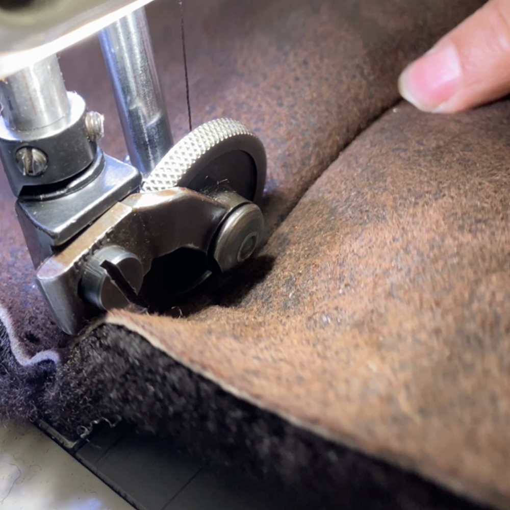A craftsperson cutting material for a jacket